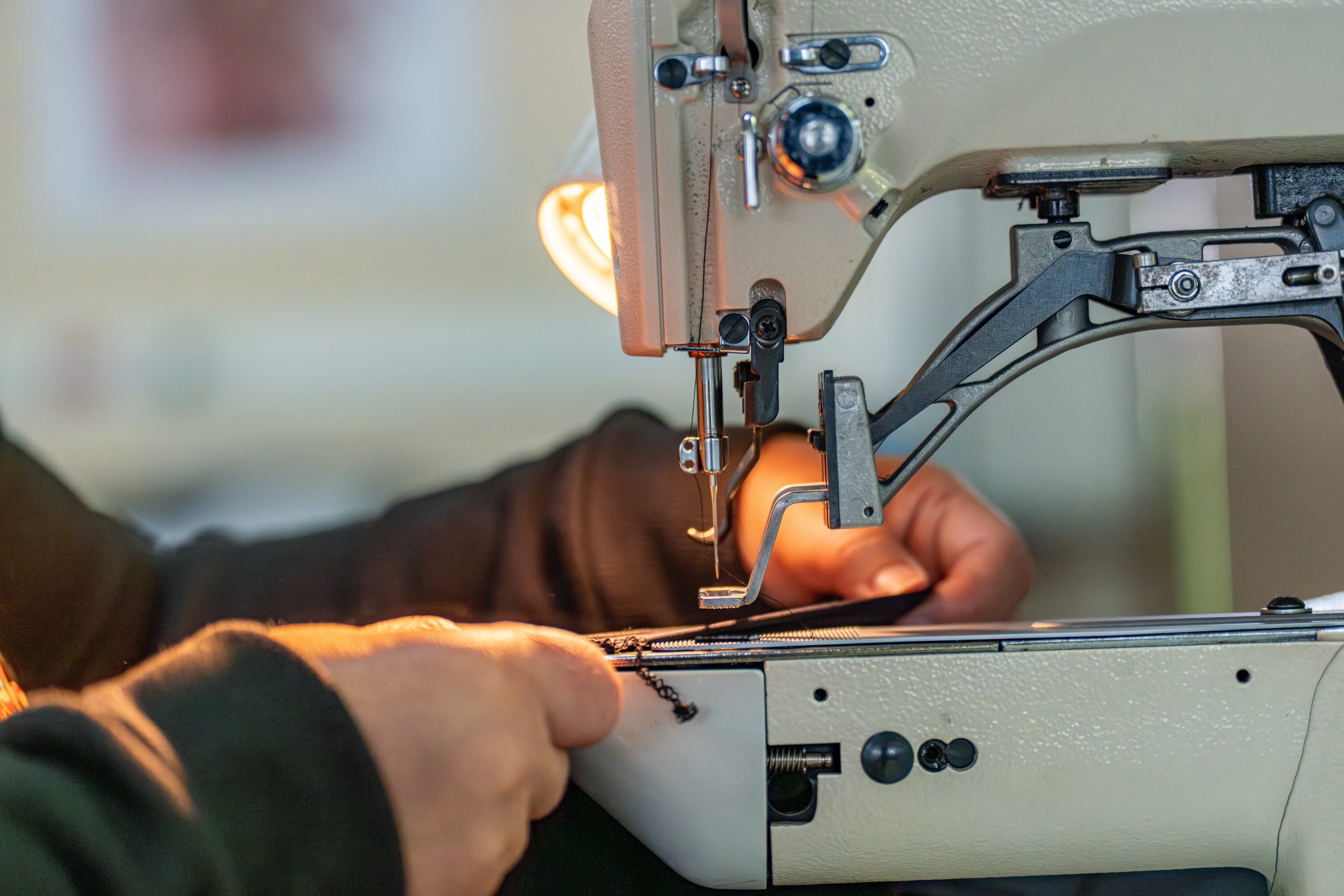 Personnes en pleine couture sous une lumière tamisée, créant une atmosphère chaleureuse et concentrée.